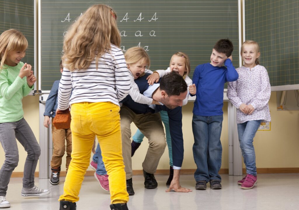 Teacher with playful pupils in classroom